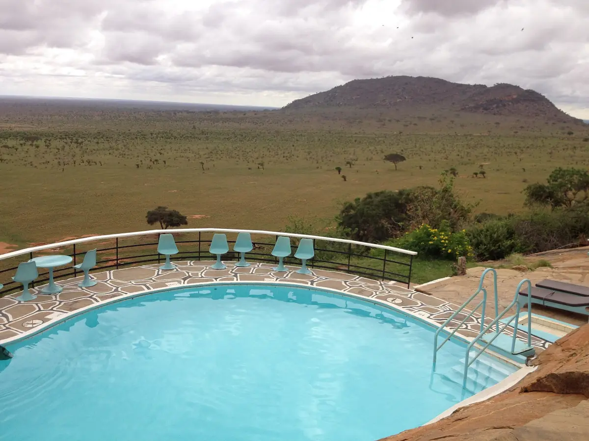 Lodge swimming pool with a view over the Tsavo East plains and a hill